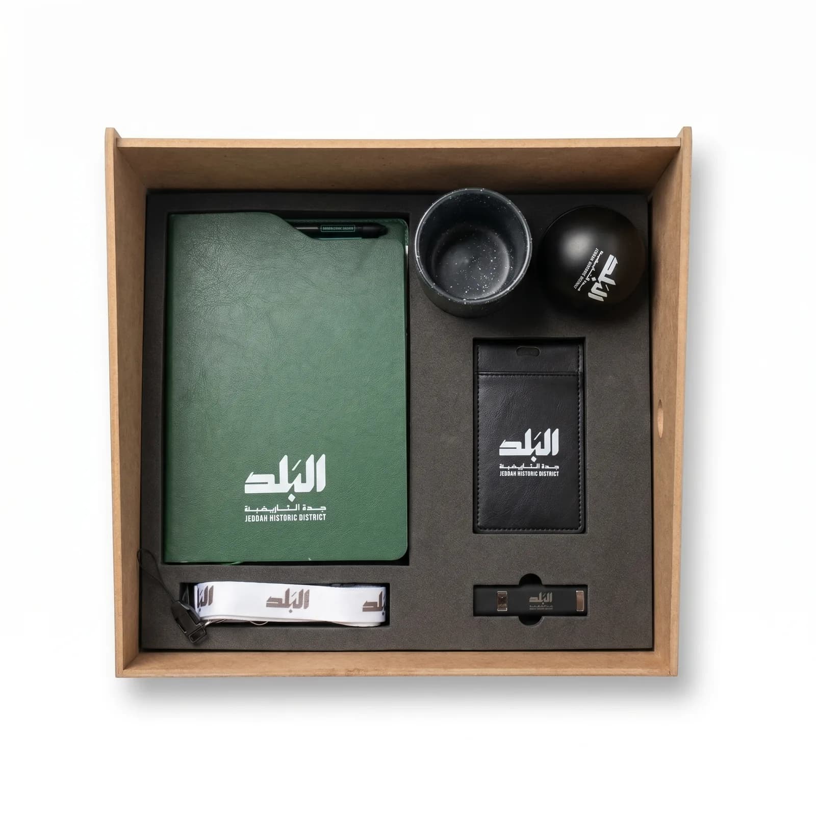A welcome kit Vista made for Jeddah Historic District: notebook, pen, lanyard, badge holder, cup, stress ball and USB in a fitted wooden box.